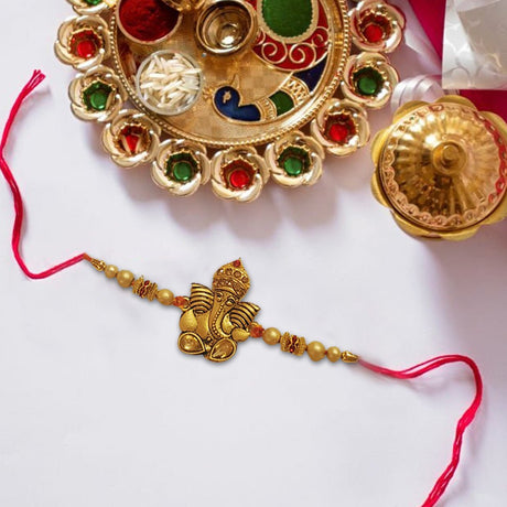 Ganesha Rakhi With Pearls Golden Finish - Rakhi | Desimart